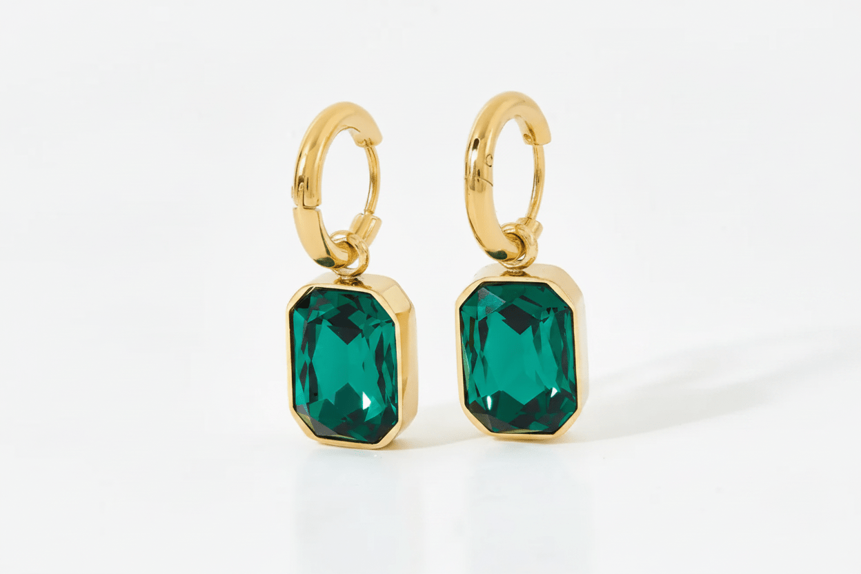 Green Gemma Earrings by Glitze Accessories featuring sparkling green gemstones and delicate gold-tone hooks.