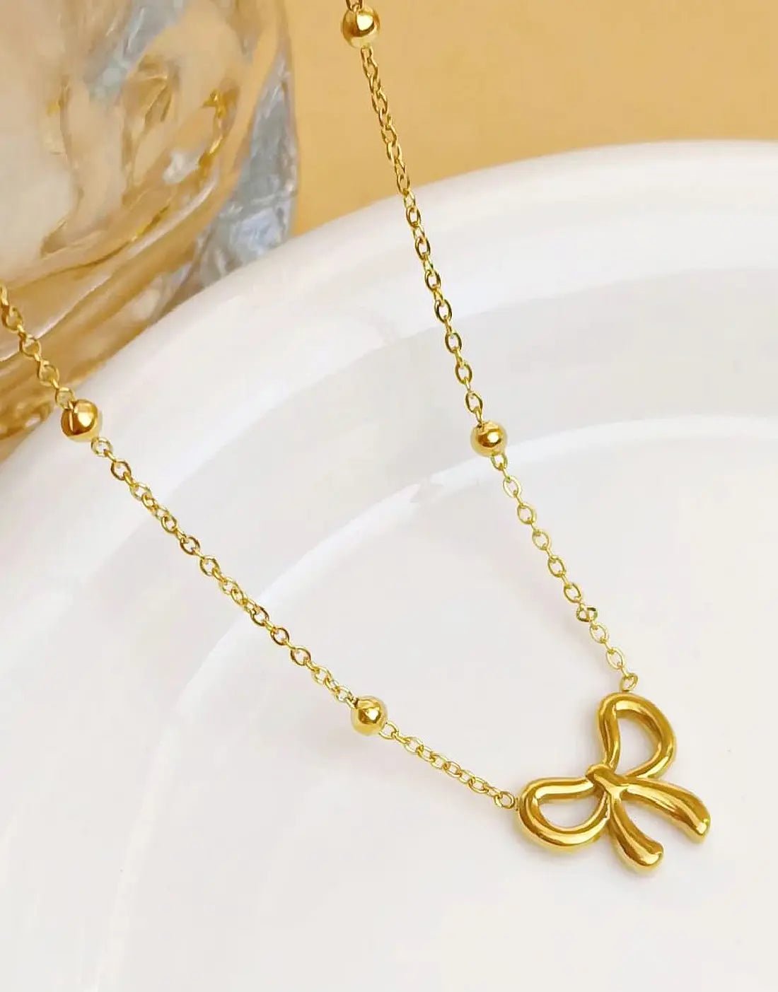 Simple Bowelle necklace by Glitze Accessories featuring a delicate chain and elegant bow pendant.